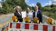 Verkehrsstaatssekretärin Susanne Henckel und Radverkehrsmanagerin Birgit Schucht vom Kreis Pinneberg überreichen Jürgen Scharley, zweiter stellvertretender Bürgermeister der Stadt Quickborn, die Fördermittelbescheide für den Umbau der Pascalstraße