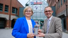 Norderstedts Oberbürgermeisterin Katrin Schmieder (links im Bild) und Schleswig-Holsteins Digitalisierungsminister Dirk Schrödter präsentieren vor dem Norderstedter Rathaus die neue Norderstedter Stadt-App. (Foto/Copyright: Stadt Norderstedt)